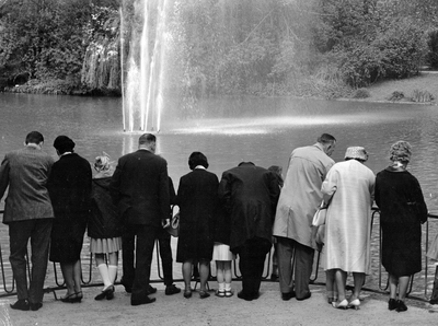 361131 Afbeelding van een groep personen bij de vijver met fontein in het Julianapark te Utrecht, op een zondagmorgen.